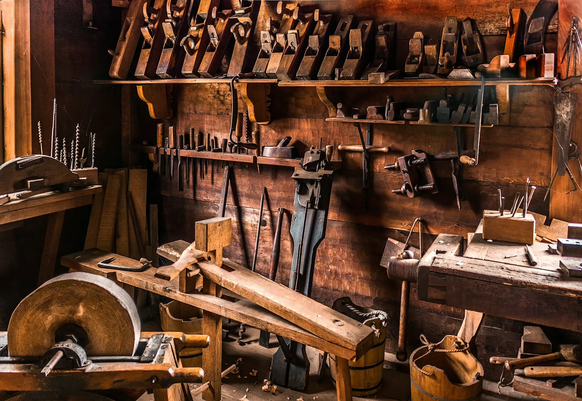 Hands working a pen at a woodworking bench